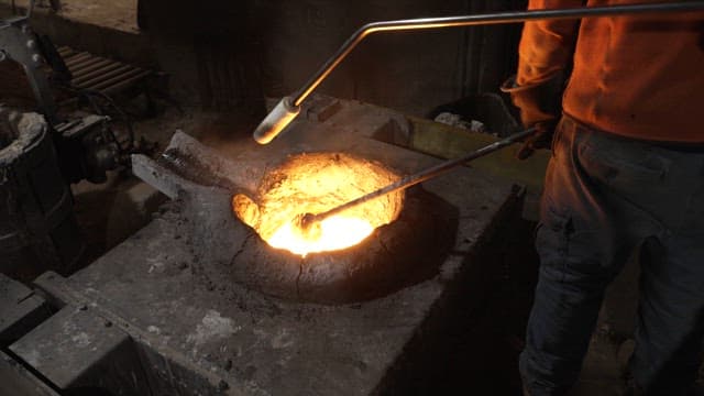Worker handling molten metal in a foundry
