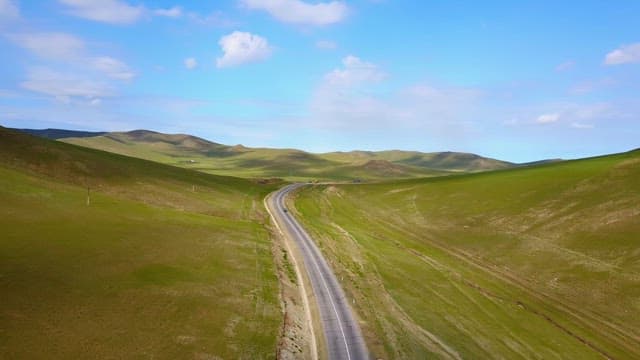 Winding road through green hills