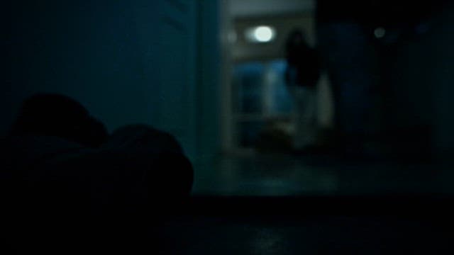 Silhouettes of Two People Moving in a Dark Room