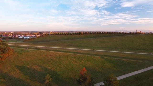 Green hill under a colorful sky during sunset