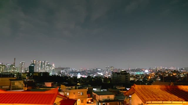 Night skyline of a brightly lit city from a rooftop
