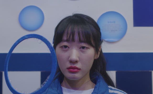 Woman wearing blue clothes blowing bubbles with her mouth