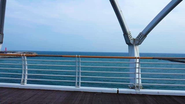 Serene Seaside and Bridge with Metal Railing