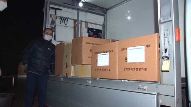 Workers Transporting Boxes Containing CSAT Test Papers at Night