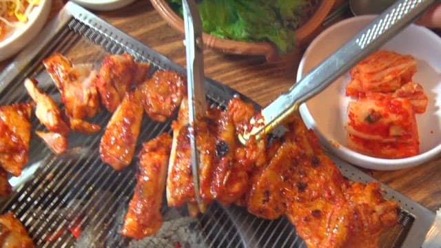 Spicy charcoal-grilled chicken cut on the grill