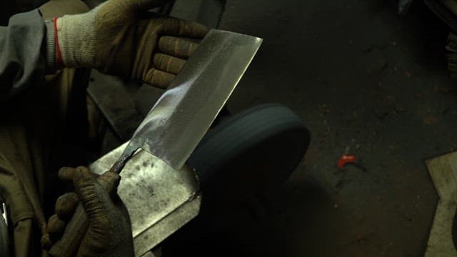 Worker sharpening a knife with sparks