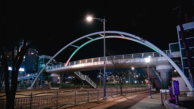 Quiet pedestrian overpass and roadway at night