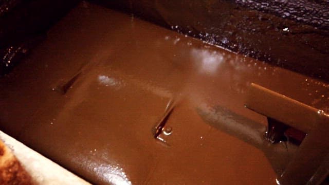 Chocolate being mixed in a machine in an industrial tank