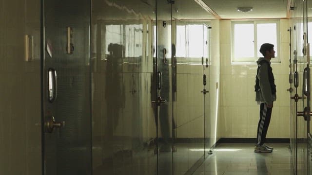 Person with his head down in a dark hallway