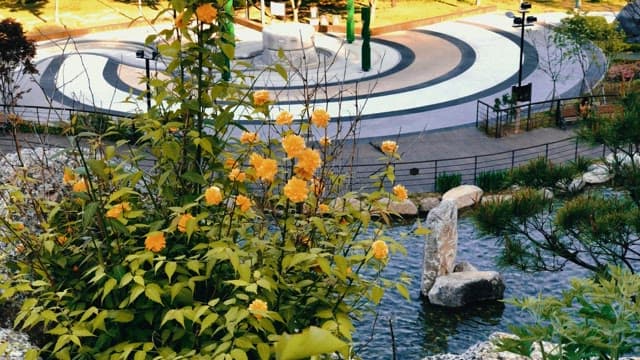 Yellow flowers in a serene park with a circular structure