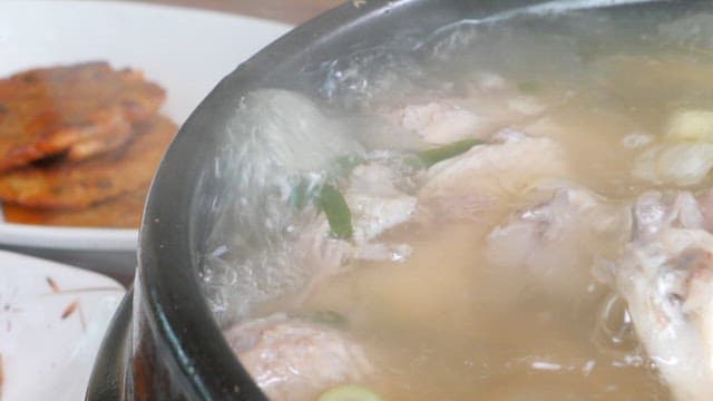 Summer health food made with medicinal herbs, Samgyetang, is boiling