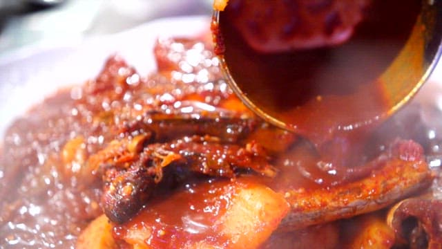 Spicy assorted braised fish with sauce being poured