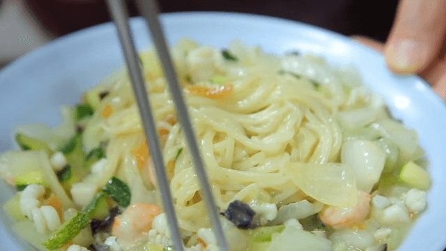 Mixing seafood and vegetable jjajangmyeon with chopsticks