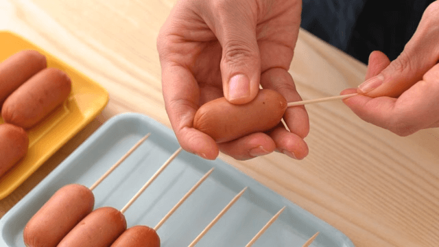 Scene of putting a sausage on a toothpick