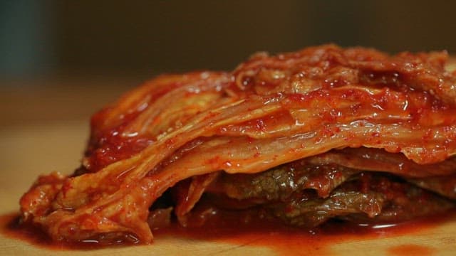 Kimchi with large-eyed herring being prepared on a wooden board