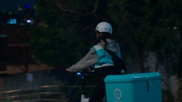 Delivery Worker Navigating Nighttime City Streets