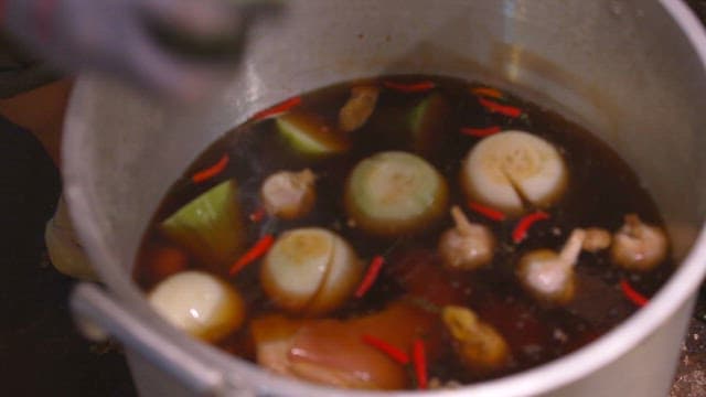 Boiling onions and spices in a large pot to make broth
