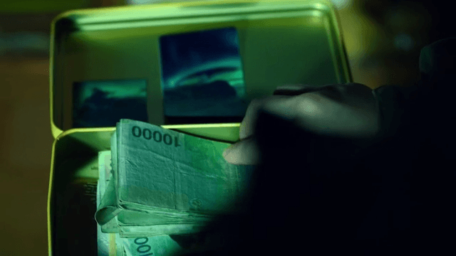 Person opening a tin case containing emergency fund