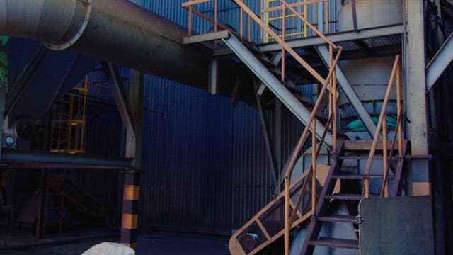Worker Climbing Stairs at an Industrial Site