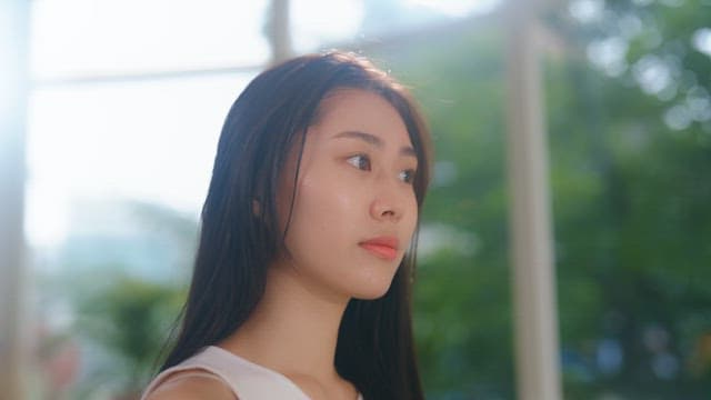 Woman drying her hair with a hair dryer in the sunshine