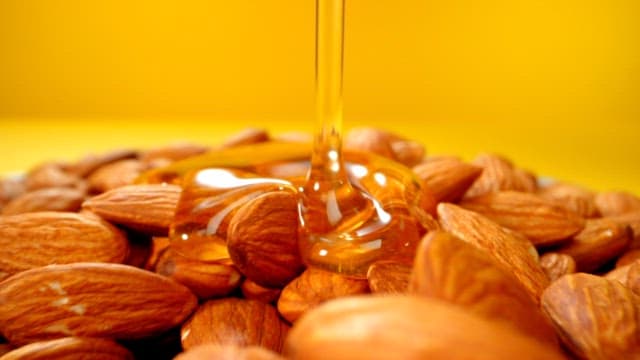 Honey being poured over almonds