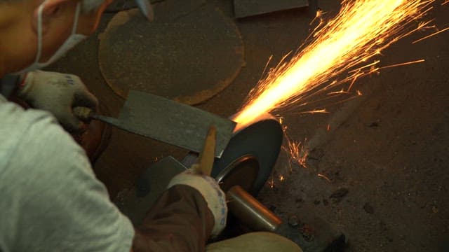 Worker sharpening a knife in a workshop