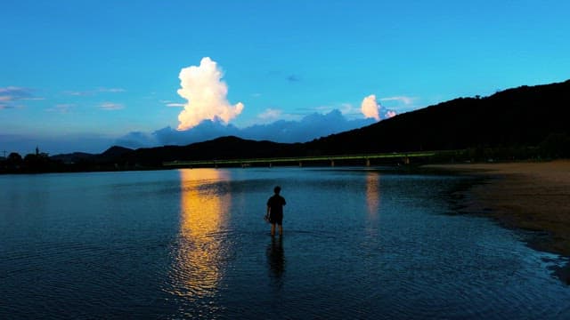 Person Standing by the Late at Dusk