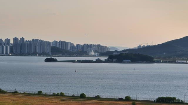 City skyline with a sea and distant hills