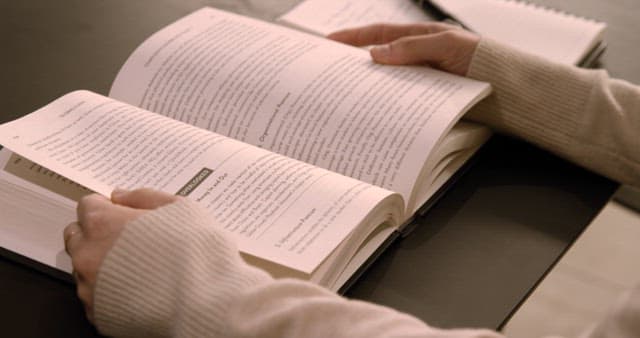 Person Studying by Reading an Open Book