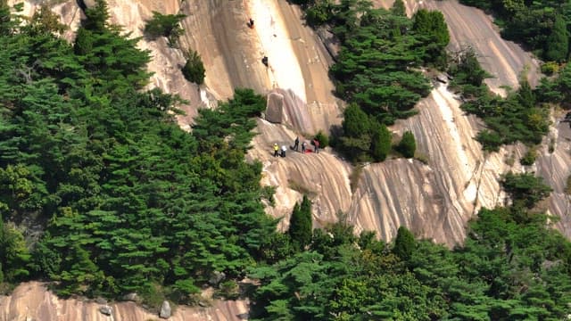 People climbing a steep mountain slope