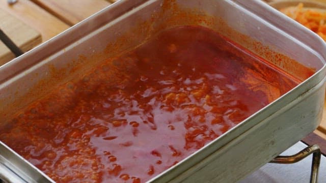 Soft tofu stew cooked in a portable metal pot