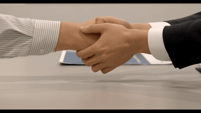 Business People Shaking Hands at a Table in Office
