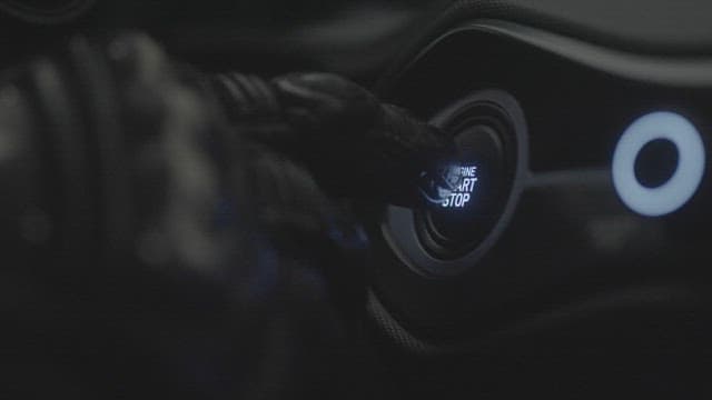 Hand Pressing the Button to Start the Engine of a Sports Car