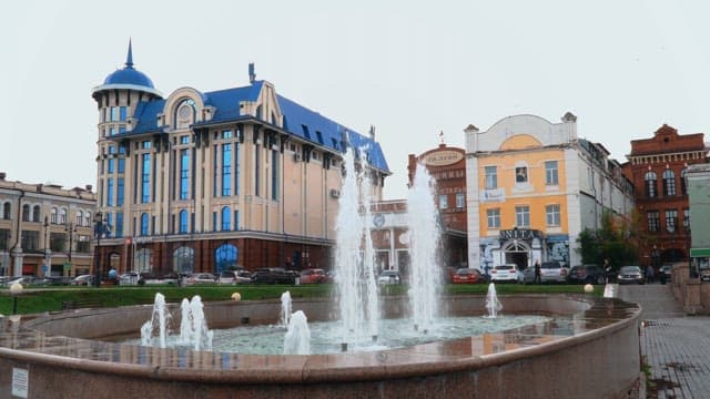 Fountain at Lenin Square in front of historical buildings on a cloudy day