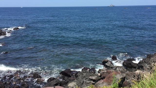Rocky Seashore with Passing Boats