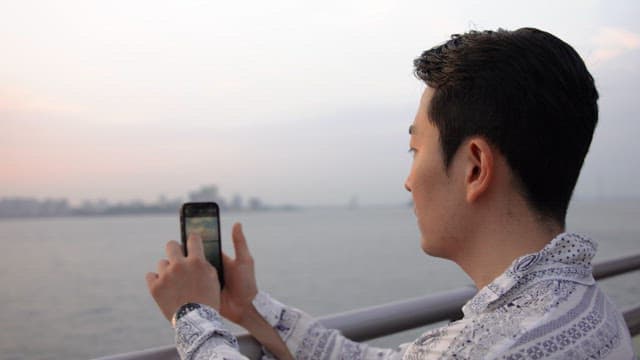Man taking photos by the seaside