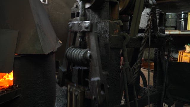 Worker forging metal in a factory