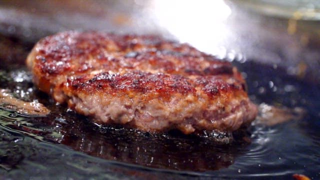Juicy burger patty sizzling on a grill