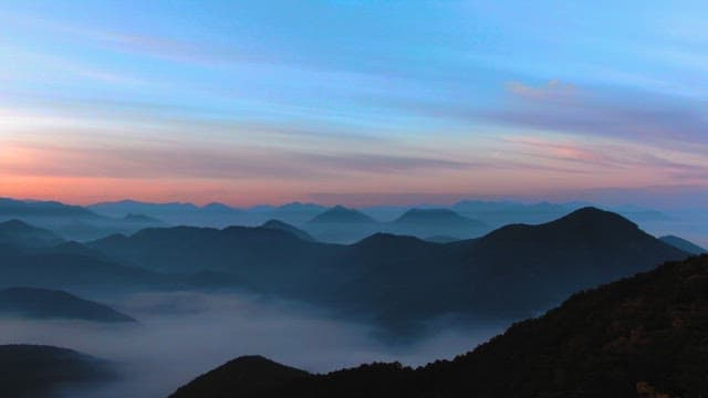 Dawn Breaking Over Misty Mountain Range
