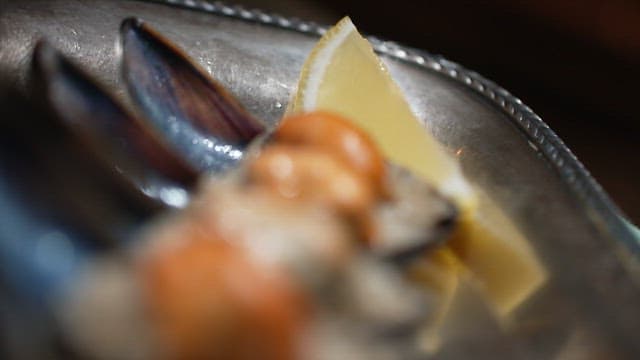 Gourmet mussels with fresh lemon on a metal plate
