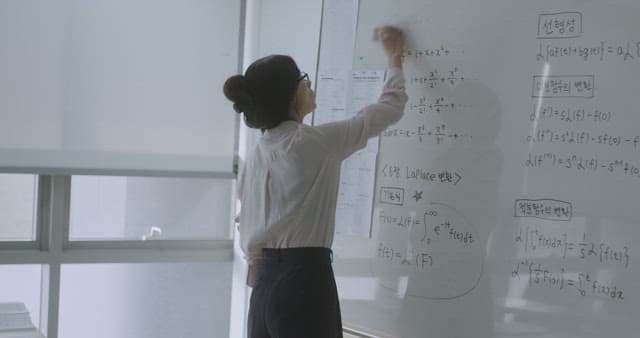 Teacher erasing writing on the whiteboard