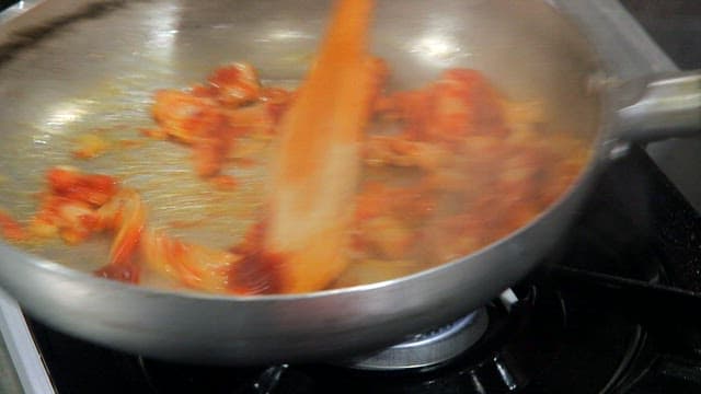 Kimchi being stir-fried in a pan