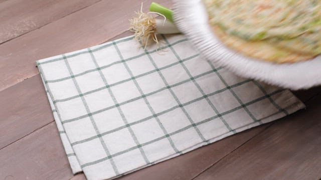 Green onion pancake on a table with green onions
