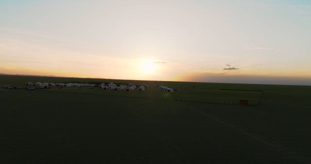Serene landscape at sunset with traditional yurts