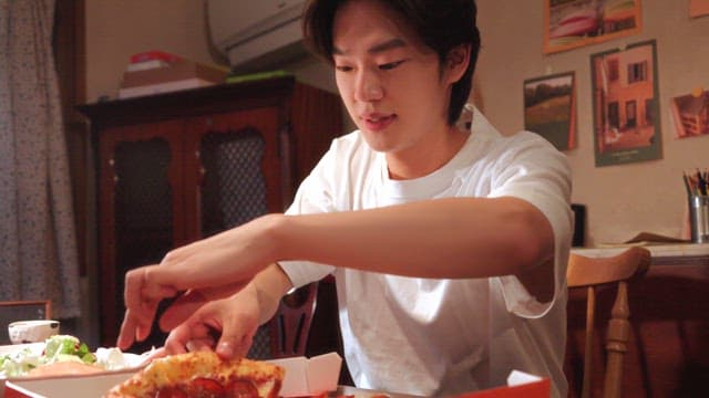 Young man enjoying pizza indoors