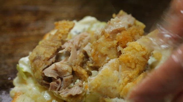 Fried chicken cut with scissors on bread