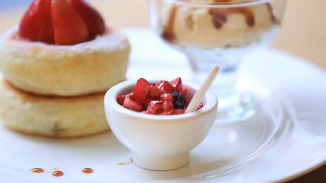 Plate of strawberry-topped griddlecake with sugar filling and ice cream