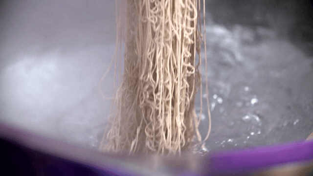 Noodles being extruded into boiling water