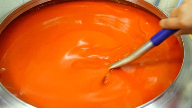 Stirring red sauce in a large pot