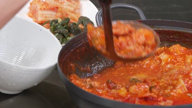 Scooping up the Delicious Pork Stew and Putting it in a Bowl